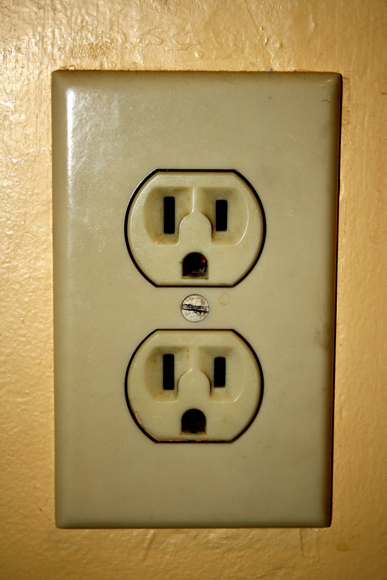 Exterior face of a grounded US household electrical outlet